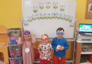 Dzieci w maskach prezentują swoje medale.